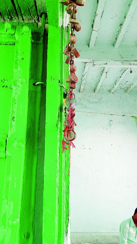 Threads and locks, put up by devotees, hang from an iron chain on the doorway to the shrine. 