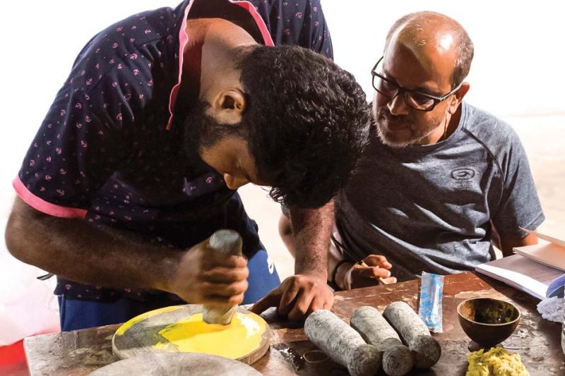 Artist P.K. Sadanandan (right) preparing colours for his work