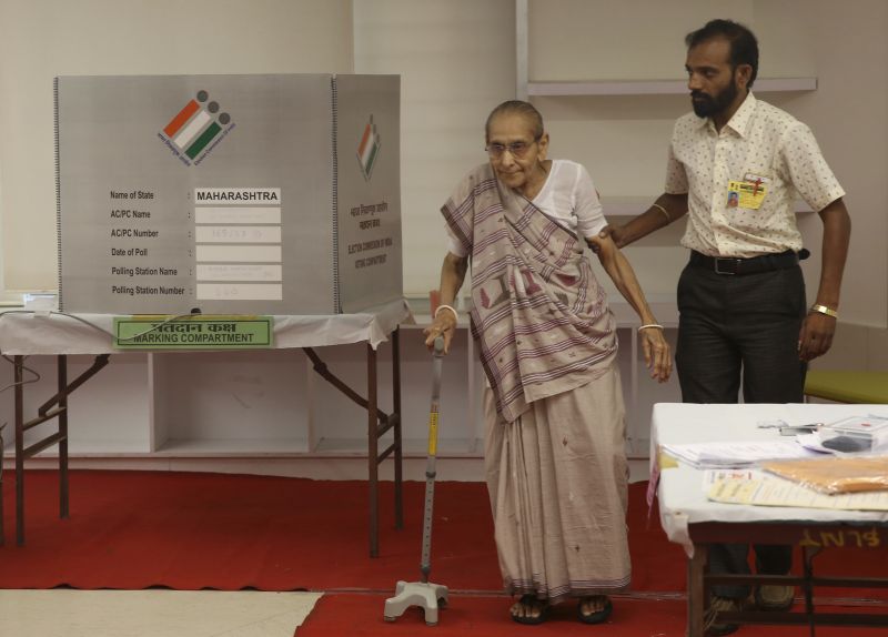 An elderly Indian citizen is assisted by a polling staff as she prepares to leave after voting at a polling center during the fourth phase of general elections in Mumbai, India, Monday, April 29, 2019. The voting over seven phases ends May 19, with counting scheduled for May 23. (Photo:AP)