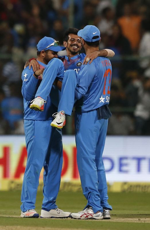 Yuvraj Singh (R) and Suresh Raina (L) pick up Yuzvendra Chahal after he picked up six wickets in the Bengaluru T20. (Photo: AP)