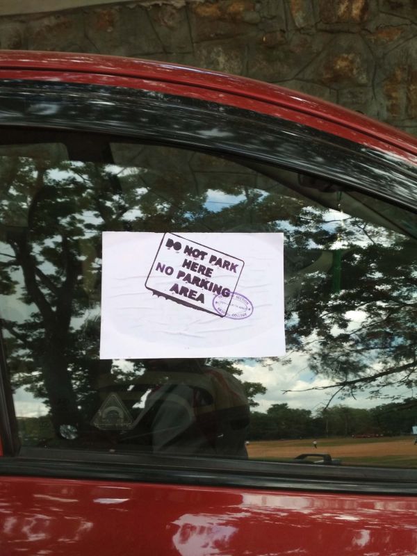 A sticker pasted on a car parked on the no-parking zone enroute Priyadarshini Institute of Paramedical Sciences.