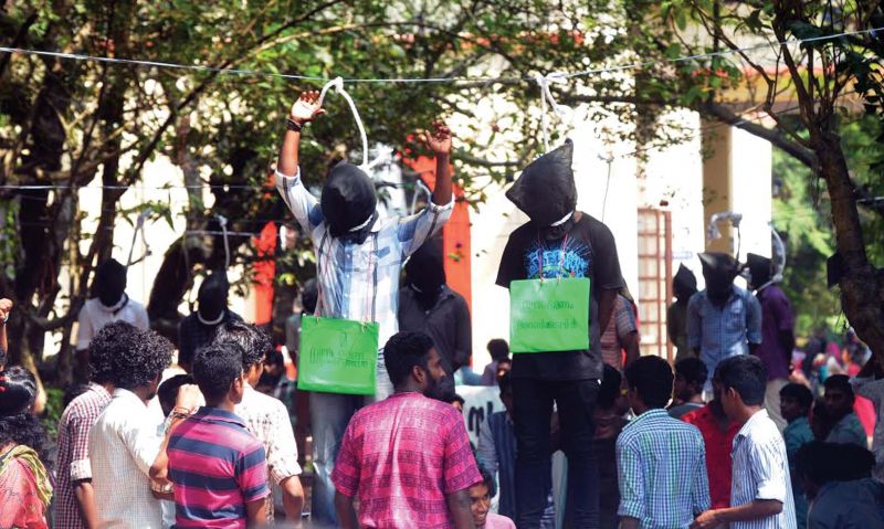 Students under the banner of Maharaja's College Protection Council stage their symbolic suicide against the move to grant autonomy to the college. (Photo: DC)