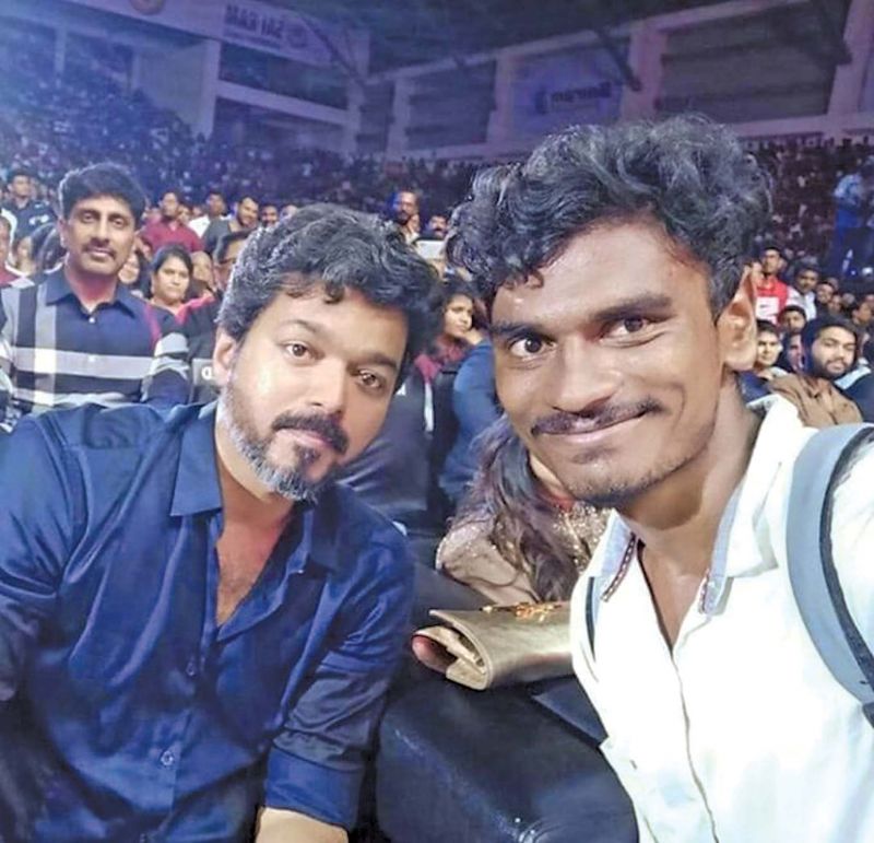Vijay poses for a selfie with a lucky fan at the audio launch 