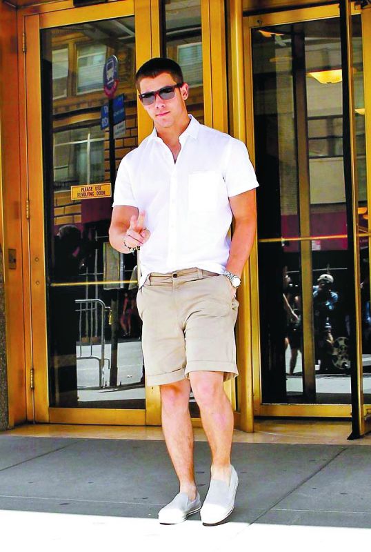Nick Jonas sporting a white shirt with shorts.