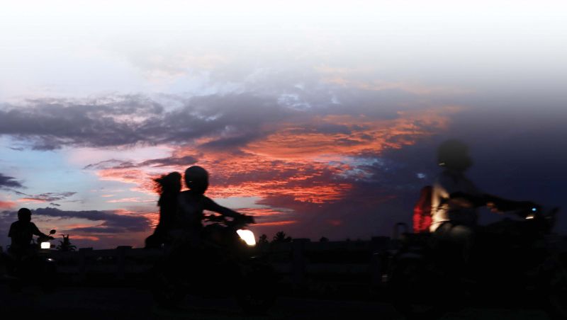 Bike riders silhouetted against a dazzling evening sky in Kochi. 	(Photo: ARUN CHANDRABOSE)