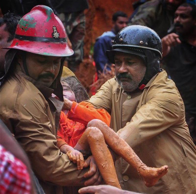 Fire Services personnel rescue a child following a landslide, triggered by heavy rains, in Idukki, Kerala. (Photo: PTI)