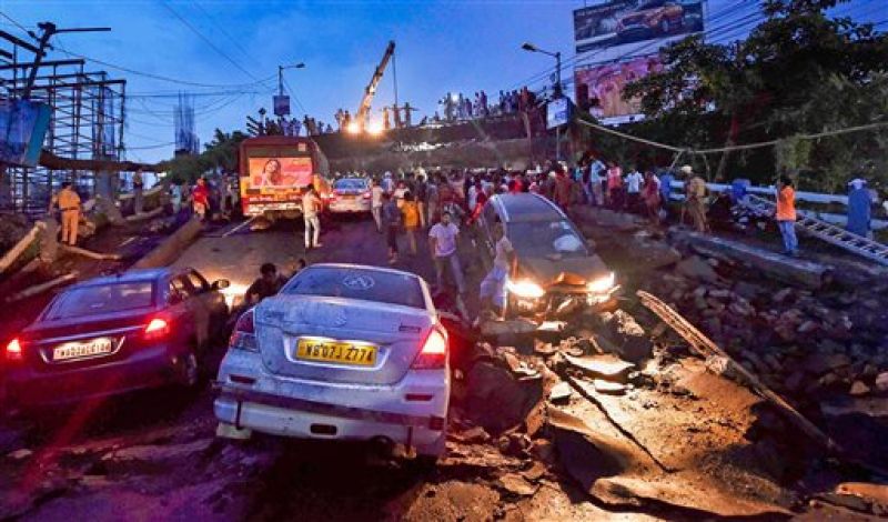 Rescue workers remove vehicles and debris from the collapsed Majerhat bridge, in Kolkata, Tuesday. (Photo: PTI)