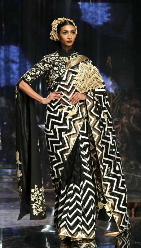 A beautiful black, white and gold sari in a geometric pattern teamed with a floral blouse with trendy floor-length sleeves. (Photo: AP) 