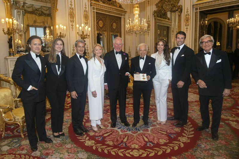 The Prince of Wales, center, presents designer Ralph Lauren, fourth right, with his honorary KBE. (Photo: AP)