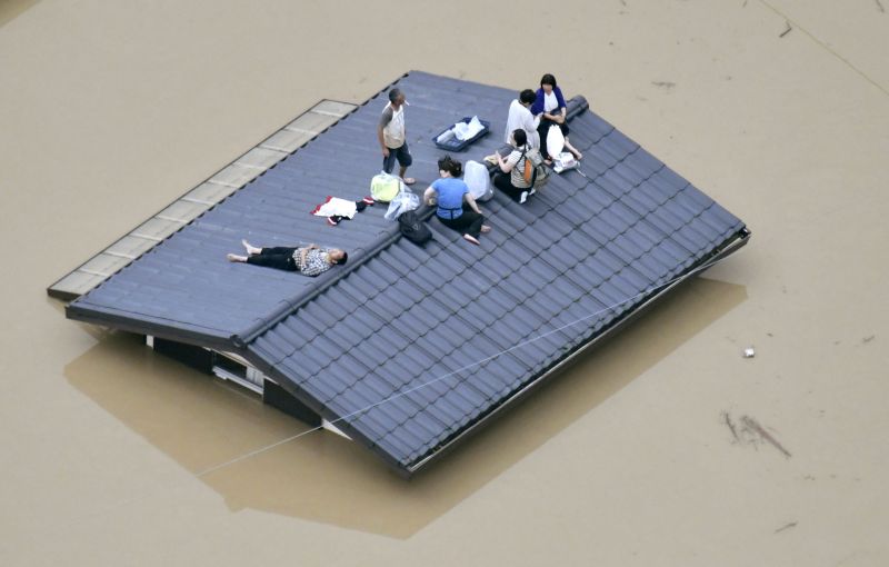 People wait to be rescued on the top of a house almost submerged in floodwaters caused by heavy rains in Kurashiki. (Photo: AP)