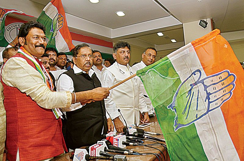 Hosapete MLA Anand Singh  waves the Congress flag after he was inducted into the party at a programme at the KPCC office in Bengaluru on Wednesday. 