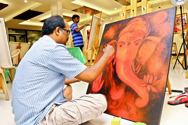 An artist making a beautiful painting of Lord Ganesha