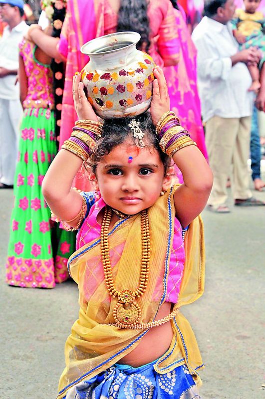 A small girl  carries Bonam at the Simhavahini Mahakali temple at Lal Darwaza.   (Pics by P. Surendra)
