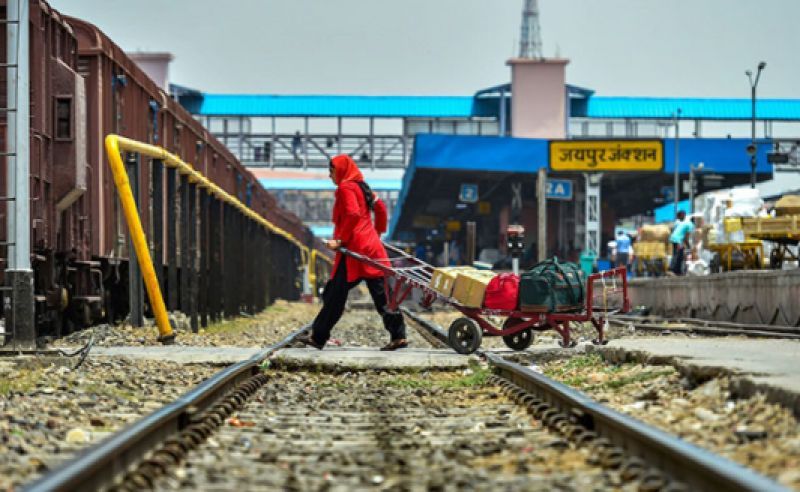 Porter Manju Devi ferries luggage across the tracks at a railway station in Jaipur, on Sunday, May 20, 2018. Being a porter is physically demanding, but with three teenagers to take care of, Manju Devi takes on everyday with great grit and determination (Photo: PTI)