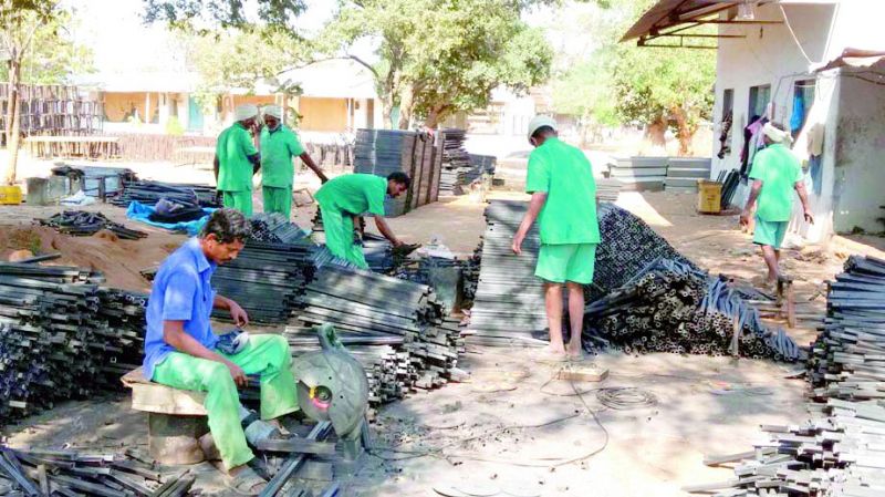 Inmates cutting and shaping the iron.