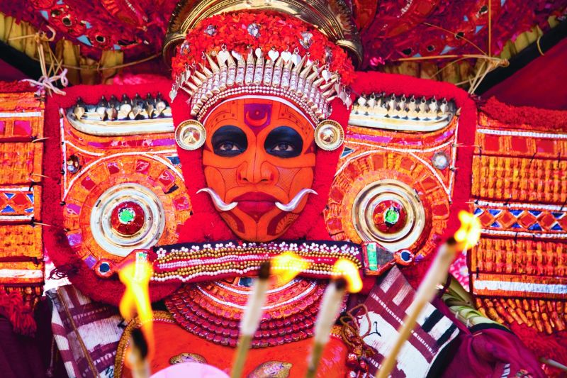 A Theyyam performer in his vibrant makeup and costume