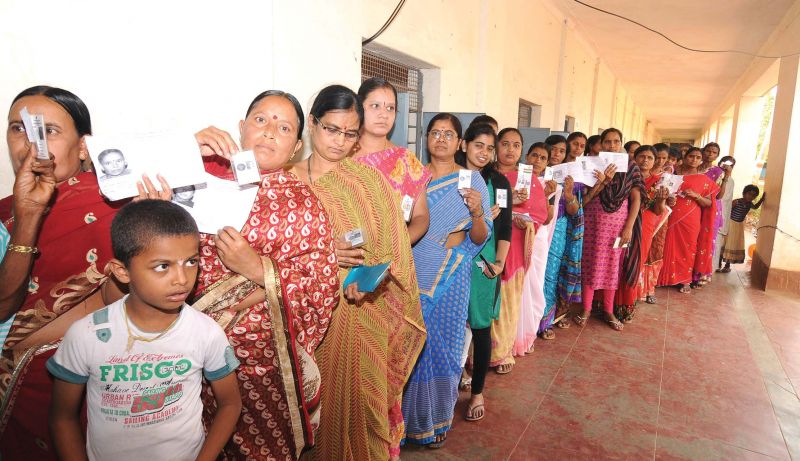 Women wait in a queue at a polling booth in Gundlupet on Sunday.