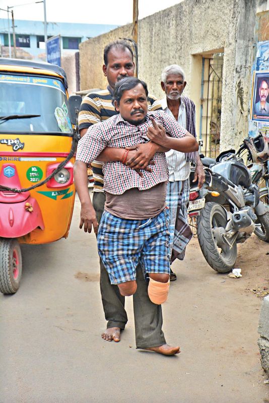 A man assists a physically challenged voter at Cheriyan Nagar, on Thursday. (Photo: DC)