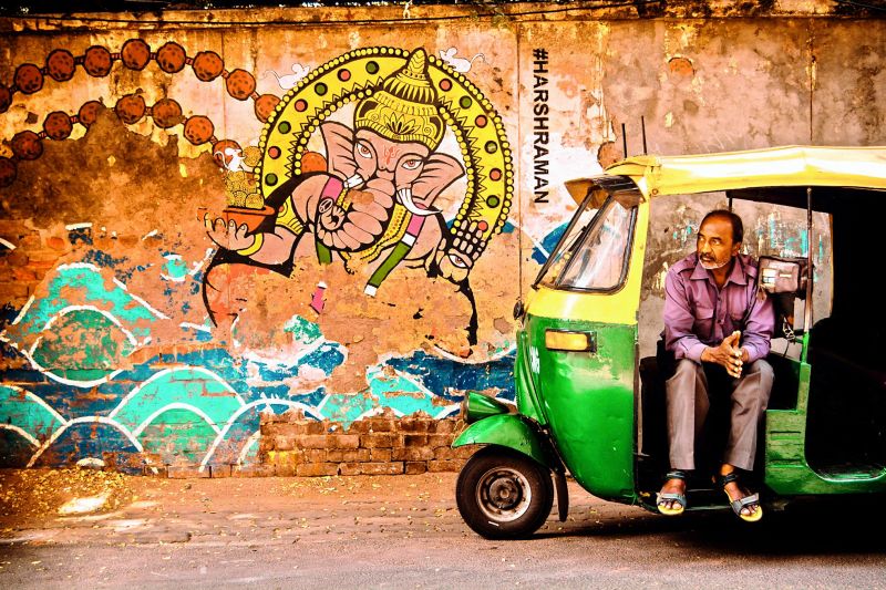 An auto-rickshaw driver awaits a ride.