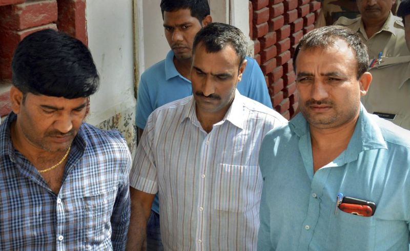 Police take Mahipal, who was accused of shooting the judge's wife and son, to a court, in Gurugram. (Photo: PTI)