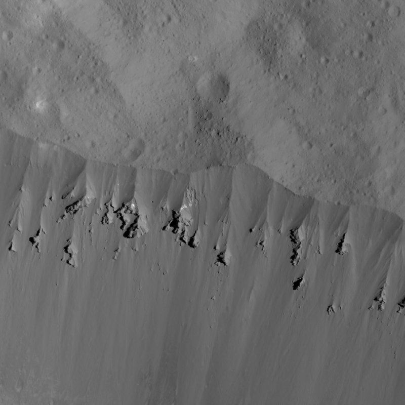 This image showing landslides along Occator Crater's rim was obtained by NASA's Dawn spacecraft on June 9, 2018 from an altitude of about 27 miles. Dawn has been orbiting Ceres since 2015, after first exploring the asteroid Vesta. They're located in the asteroid belt between the orbits of Mars and Jupiter. (NASA via AP)