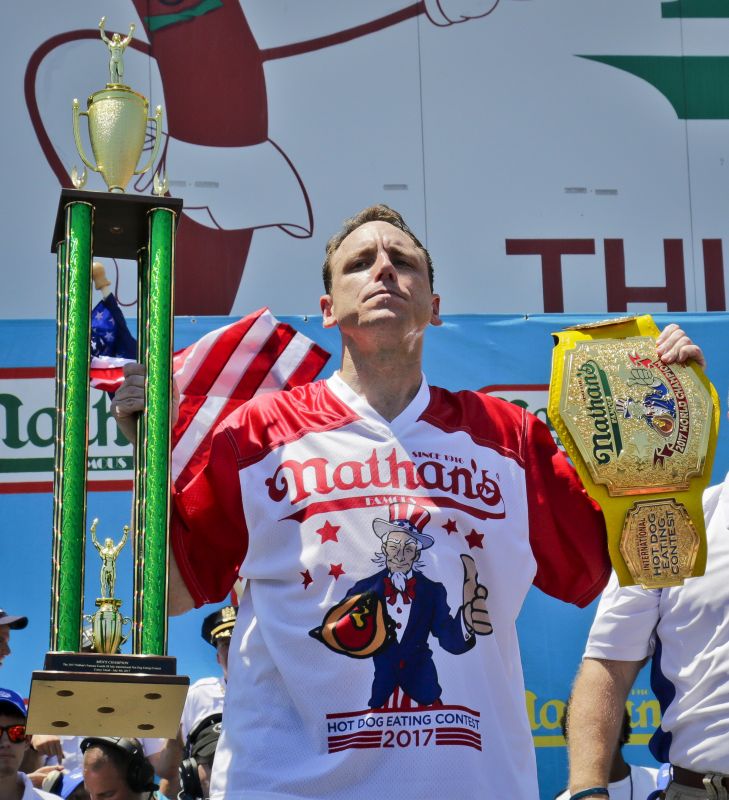 Joey Chestnut holds his trophies after winning Nathan's Annual Famous International Hot Dog Eating Contest, marking his 10th victory in the event, Tuesday July 4, 2017, in New York. (AP Photo/Bebeto Matthews)