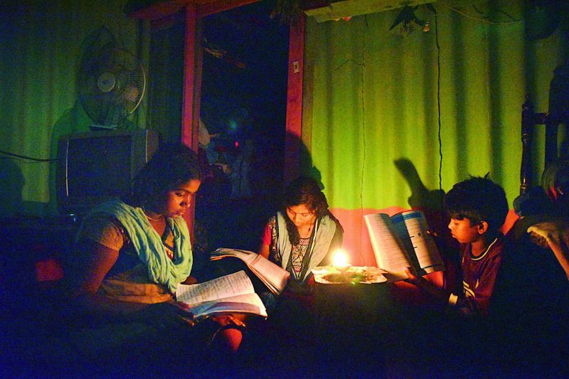 Children study under candlelight as they had no power supply in their area. 