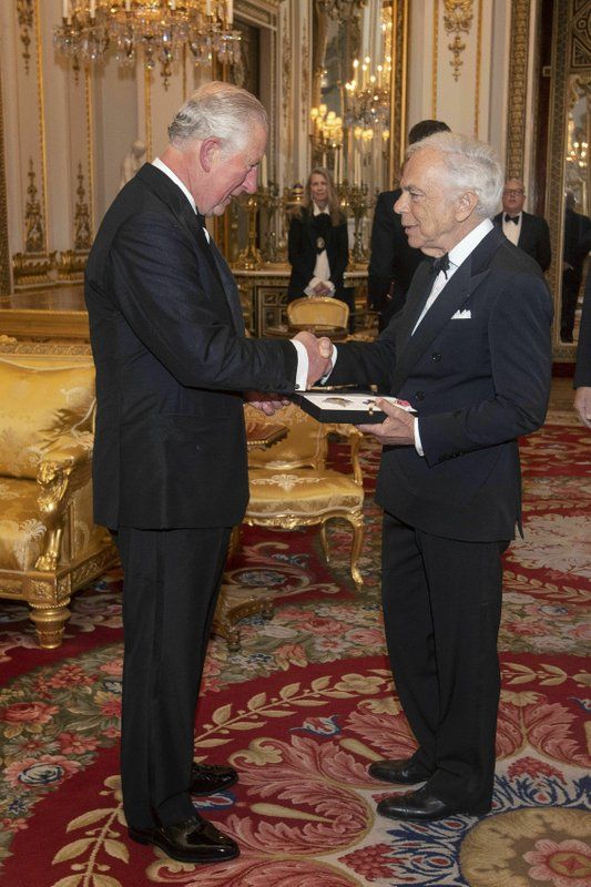 The Prince of Wales presents designer Ralph Lauren with his honorary KBE