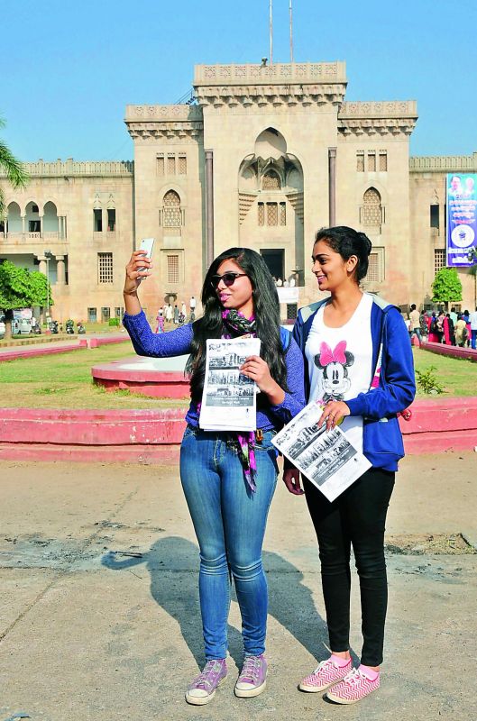 Youngsters clicking selfies in front of Arts College building.