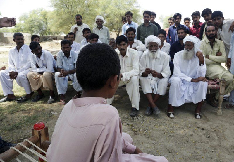 A Pakistani boy who was allegedly raped by a mullah or religious cleric, sits before villagers in Vehari, Pakistan on Aug. 18. (Photo: AP)