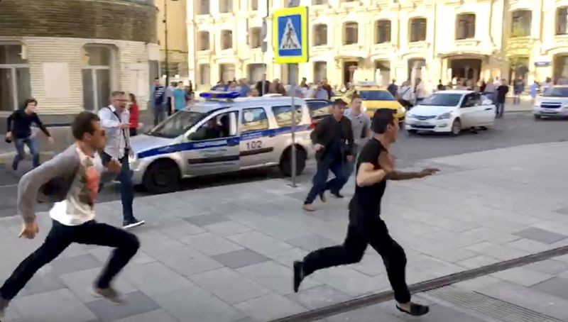 In this image taken from video provided by Viktoria Geranovich, a taxi driver, right, runs away from the scene after he crashed his taxi into pedestrians on a sidewalk near Red Square in Moscow. (Photo: AP)