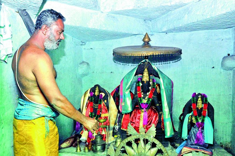 The temple priest performs puja for the deities made in black stone in the sanctum sanctorum. 