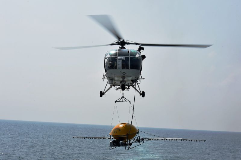 A Coast Guard helicopter arriving to land on top of a ship to take up sprinkling of chemicals to remove oil slick in the affected area on the Bay of Bengal where two ships recently collided leading to oil spill near Chennai coast. (Photo: PTI)