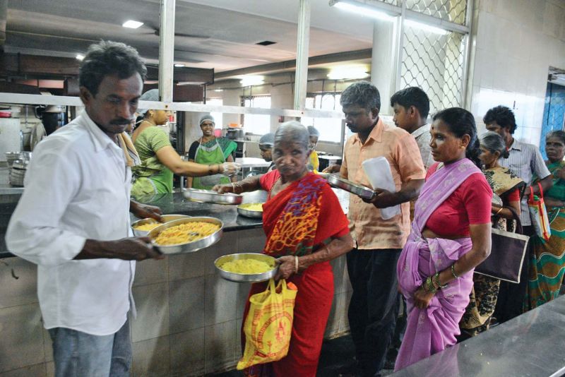 Amma canteen workers serve food to  customers.	(Photo: DC)