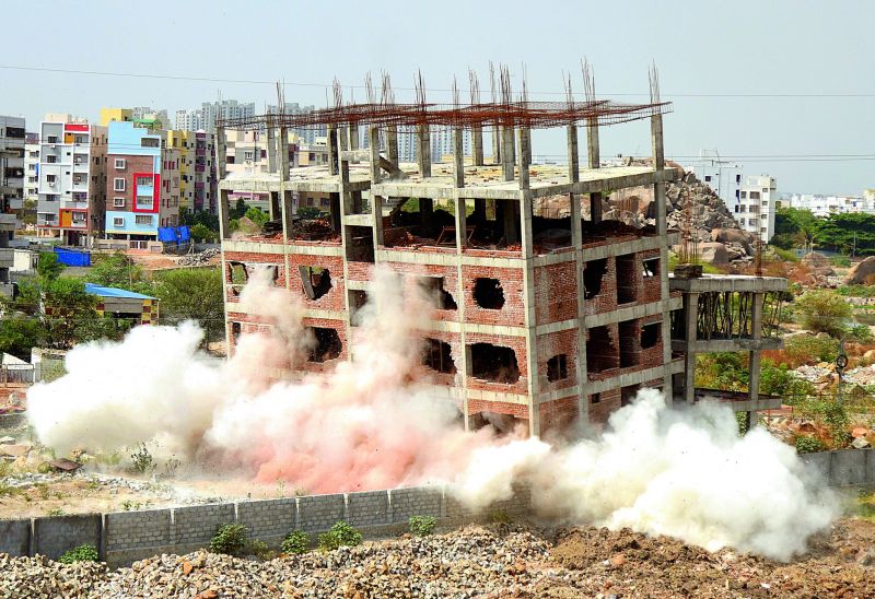 A thick cloud of dust envelopes the lower half of a building at Guttala Begumpet, where the GHMC attempted to implode an illegal structure.