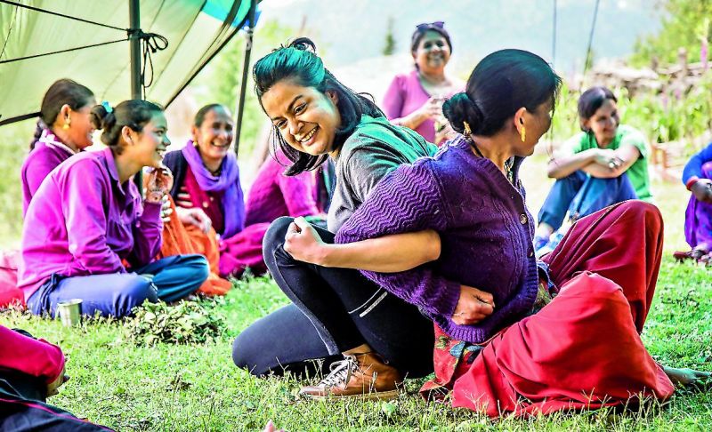 A city-based traveller enjoys a game with a local woman