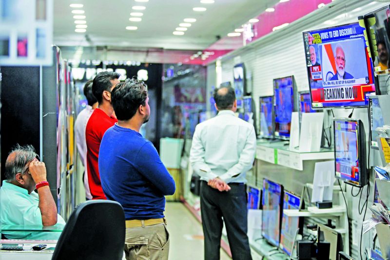 People watch Prime Minister Narendra Modi address the nation in a televised speech, at an electronics store in Jammu, India, Thursday. 	(Photo: AP)