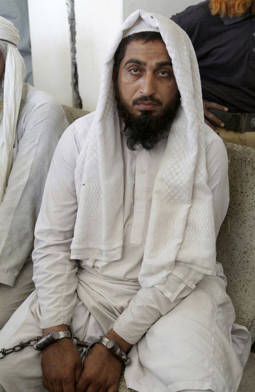A handcuffed Pakistani cleric who is accused of the rape of a student, waits for his turn outside a court. (Photo: AP)