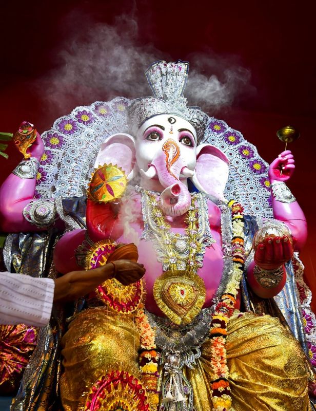 A priest offers prayers to Lord Ganesh at a community puja pandal on the occasion of Ganesh Chaturthi in Kolkata. (Photo: PTI)