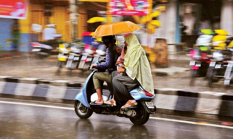 Commuters make their way in the pounding rain. (Photo: Satish.B)