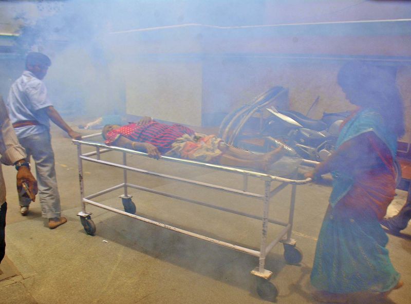 Workers at the RGGGH fog the hospital premises as a patient is moved around on a stretcher. 	(Photo: DC)