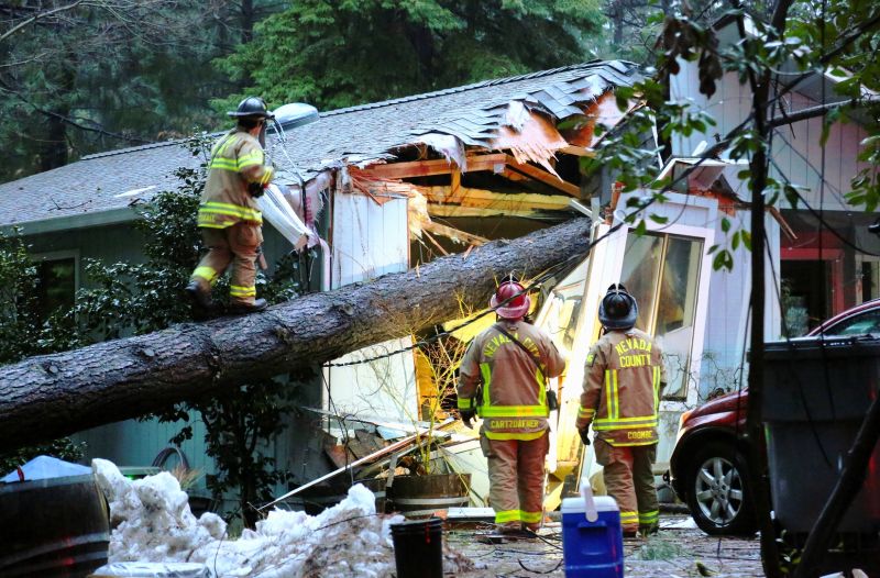 Nevada County and Nevada City firefighters work to assess a structure on Juniper Drive that sustained a tree fall, knocking out power and potentially causing a gas hazard in the process. (Photo:AP)
