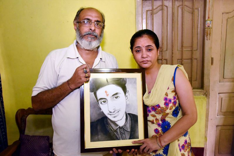 Shyam Sachdeva and Chanda Sachdeva, parents Aditya Sachdeva pose with his picture after Rocky Yadav was convicted in Gaya on Thursday. (Photo: PTI)