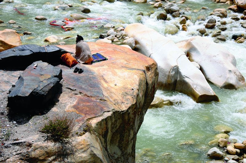 A sadhu sits in meditation on the banks of the Bhagirathi river at Gangotri