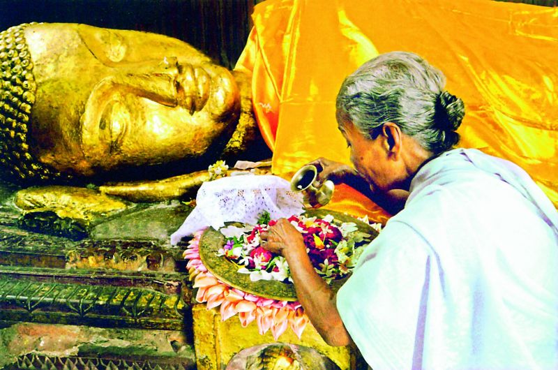 A piligrim makes offerings in front of an ancient gilded structure of the dying Buddha in Kushinagar near the place where he died, probably in his eightieth year. His last words were reported as,  Decay is inherent in all worldly things. Strive for your own liberation with diligence 