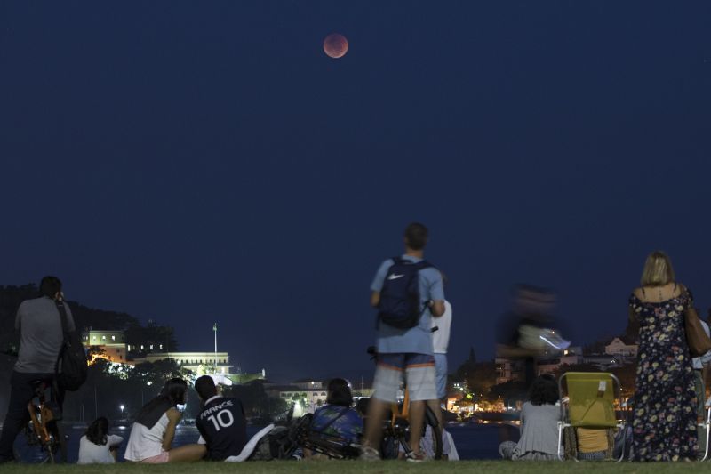 People watch a blood moon as it rises in Rio de Janeiro, Brazil, on Friday. (Photo: AP)