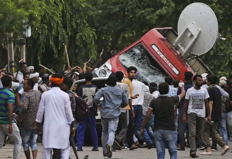 Dera Sacha Sauda sect members overturn an OB van on the streets of Panchkula on Friday. (Photo: PTI)