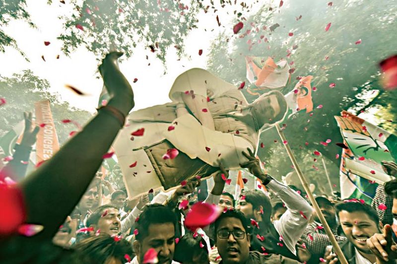 Congress Party workers display Congress President Rahul Gandhi's cutout as they celebrate after initial trends showed the party leading in the state Assembly election results, at the Congress headquarters in New Delhi on Tuesday. (Photo: PTI)
