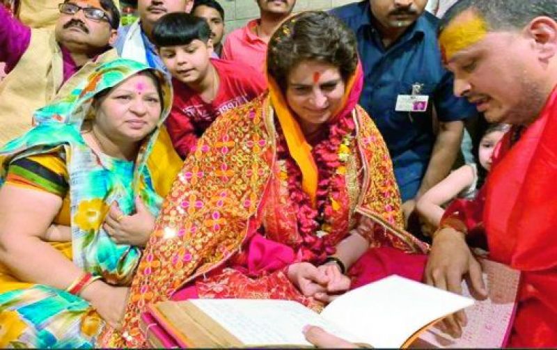 Priyanka Gandhi performs a pooja with locals before elections in bright red dupatta.