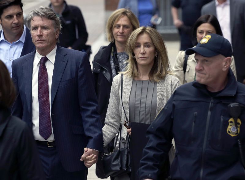 Felicity Huffman, center, departs federal court with her brother Moore Huffman Jr., left, Monday, May 13, 2019, in Boston, where she pleaded guilty to charges in a nationwide college admissions bribery scandal. (AP Photo/Steven Senne) 